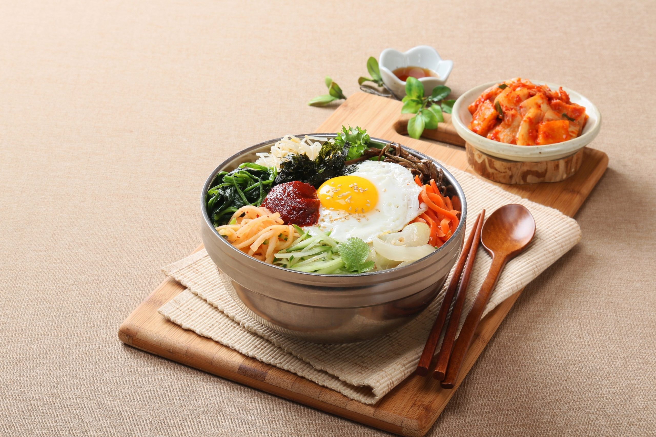 채소와 달걀을 올린 비빔밥 옆에 깍두기를 곁들인 상차림